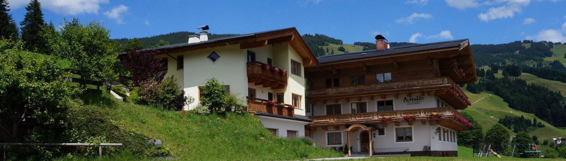 Appartementhaus AlpenHit Saalbach in sonniger Panoramalage mit Alpenblick und grüner Wiese