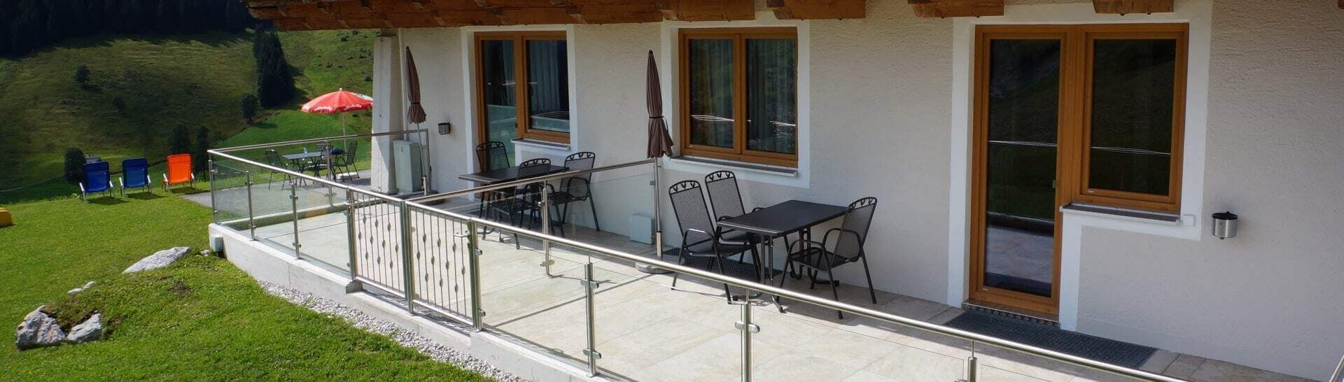 Sonnige Terrasse mit Sitzgelegenheiten vor Appartement Saalbach und Blick ins Grüne