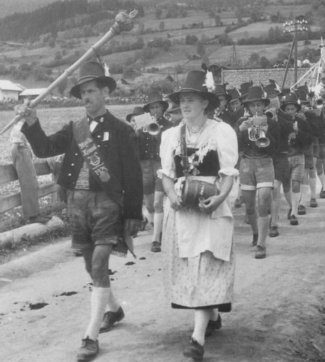 Traditioneller Blasmusikumzug mit Trachtenträgern im Pinzgau.