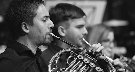 Musiker spielen auf verschiedenen Blechblasinstrumenten während eines Auftritts.