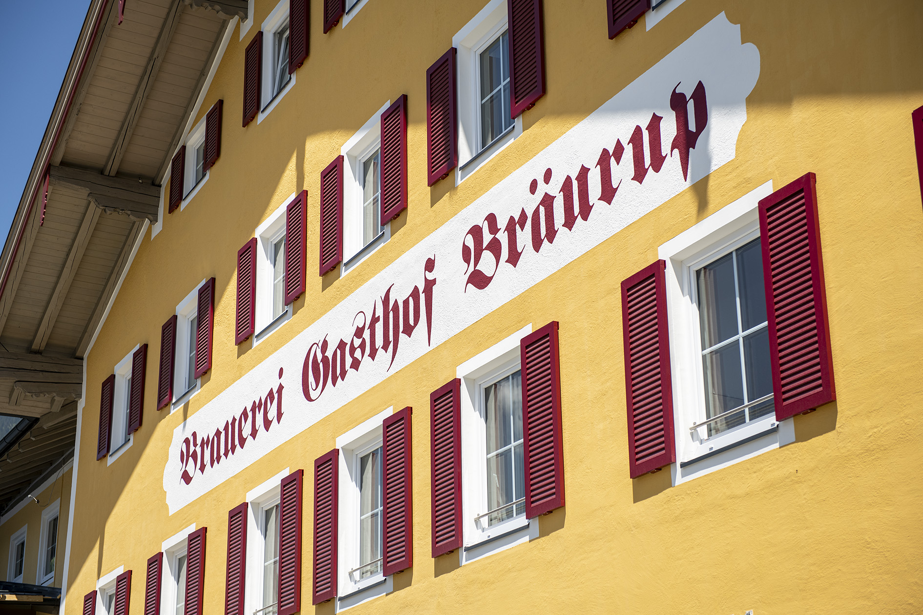 Gelbe Hotelfassade mit rotem Schriftzug Brauerei Gasthof Bräurup