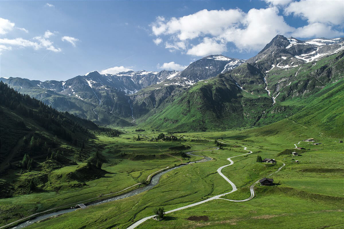 grüne alpenlandschaft mit bachlauf und wanderwegen im salzburger land berghotel naturhotel
