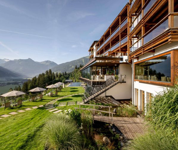 Wellnesshotel mit Panoramablick auf Alpen und Liegestühlen im Garten im Salzburger Land