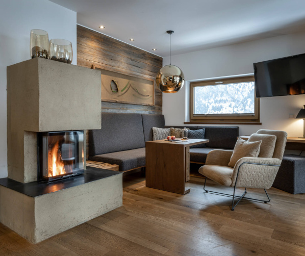 Gemütliche Lounge mit Kamin, Bergblick und modernen Sitzmöbeln im Wellnesshotel Salzburger Land