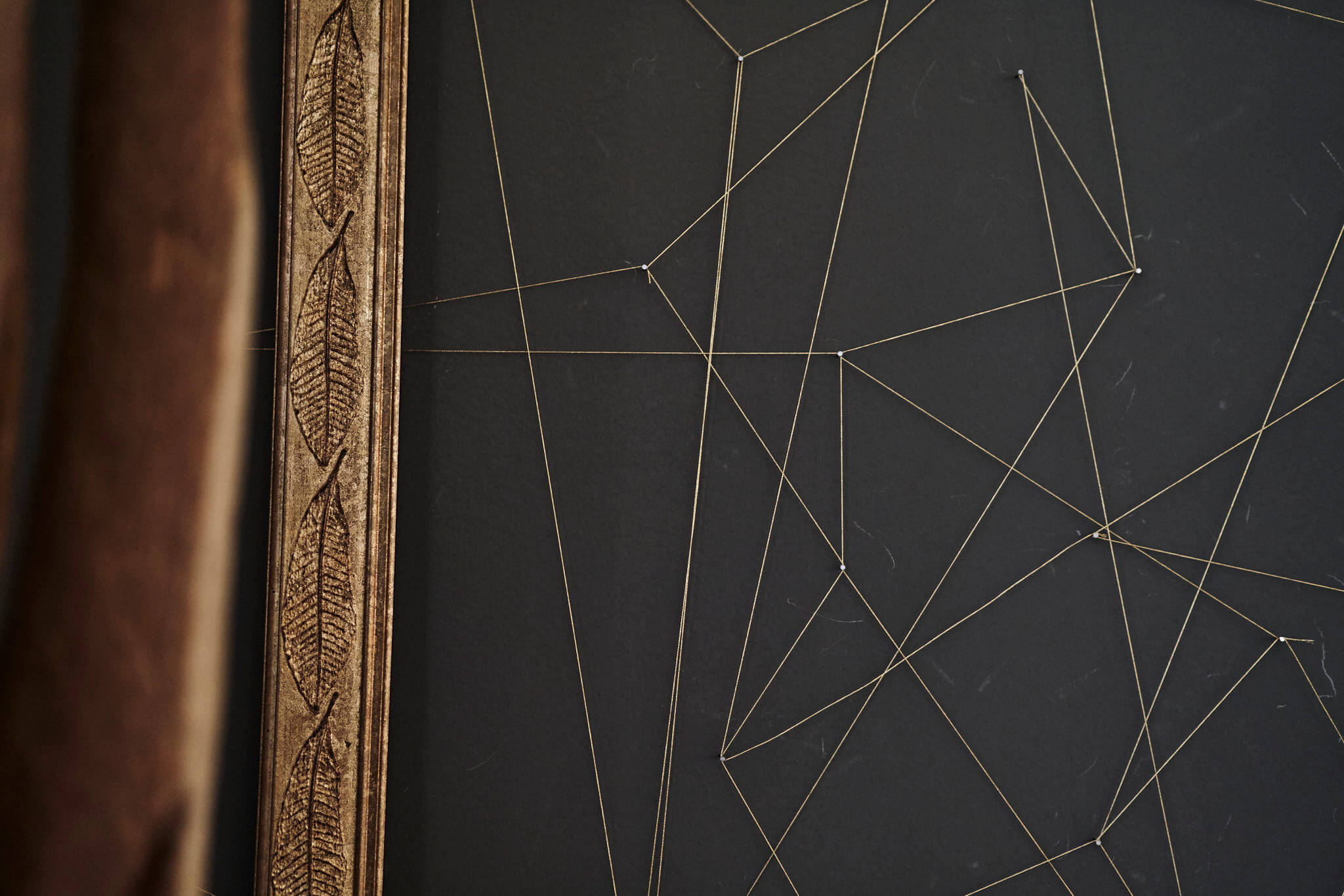Goldener Bilderrahmen mit minimalistischer Drahtkunst im Designhotel im Salzburger Land