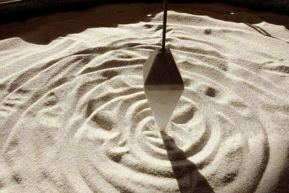 Pendulum erzeugt konzentrische Muster im Sand eines Wellnesshotels im Salzburger Land