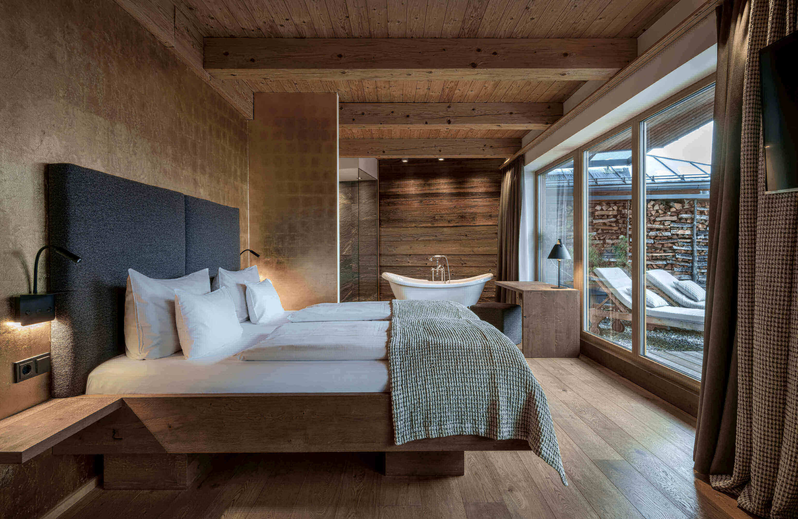 Modernes Designhotel-Zimmer mit Holzdecke, freistehender Badewanne und Panoramafenster in Bad Hofgastein
