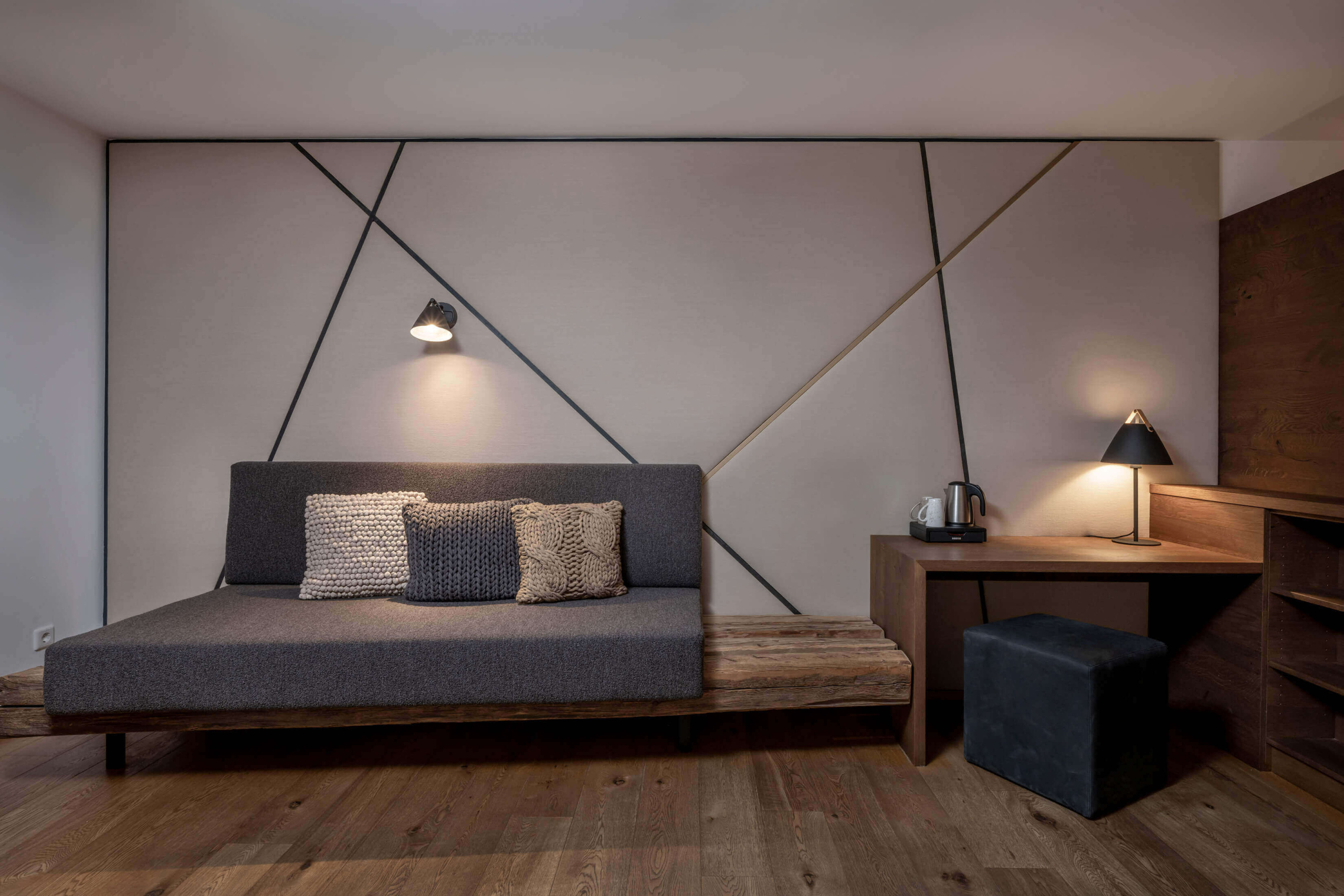 Modernes Designhotel-Zimmer mit Sofa, Holzakzenten und warmem Licht im Salzburger Land
