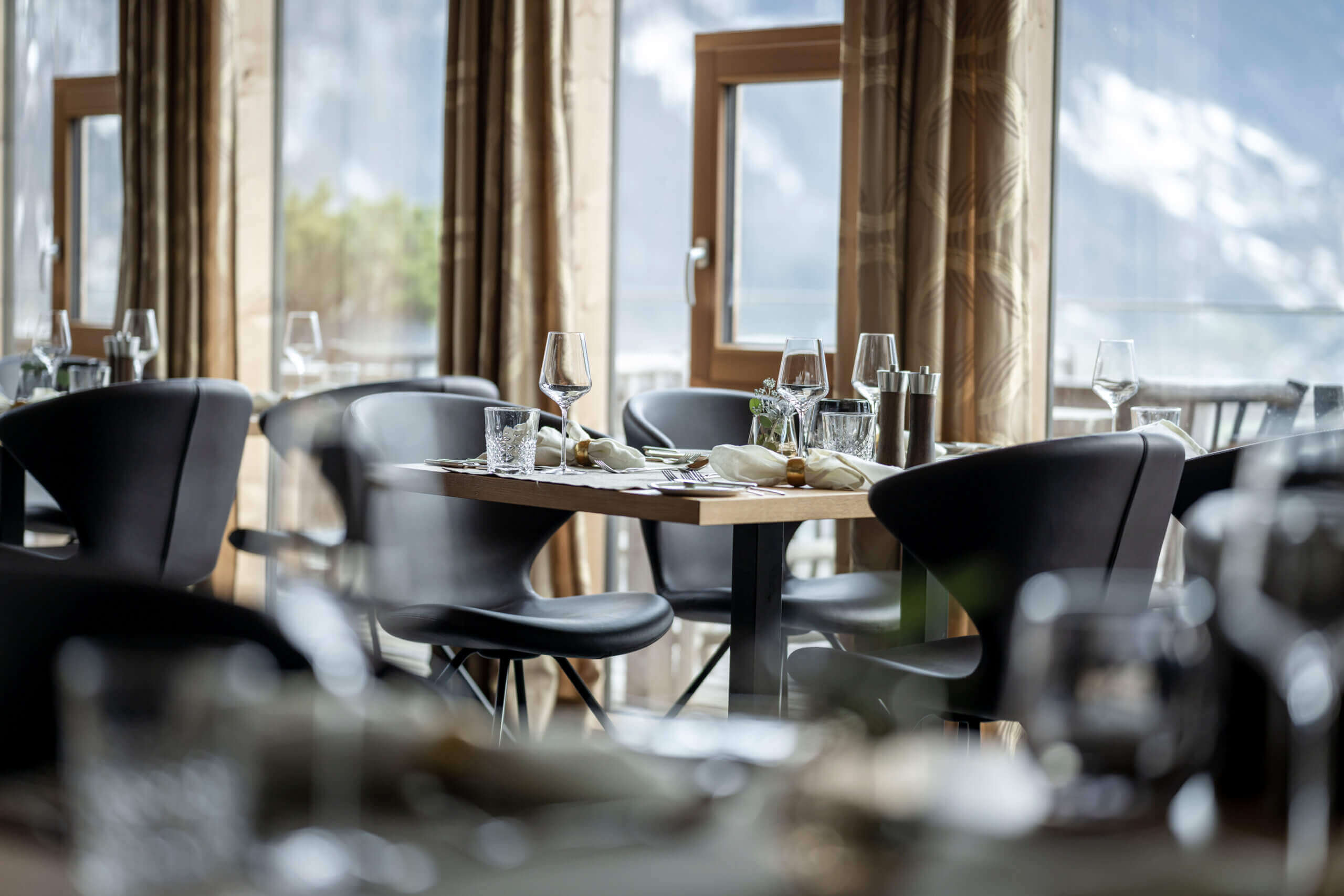 Elegantes Restaurant mit gedeckten Tischen im Designhotel DAS.GOLDBERG im Salzburger Land