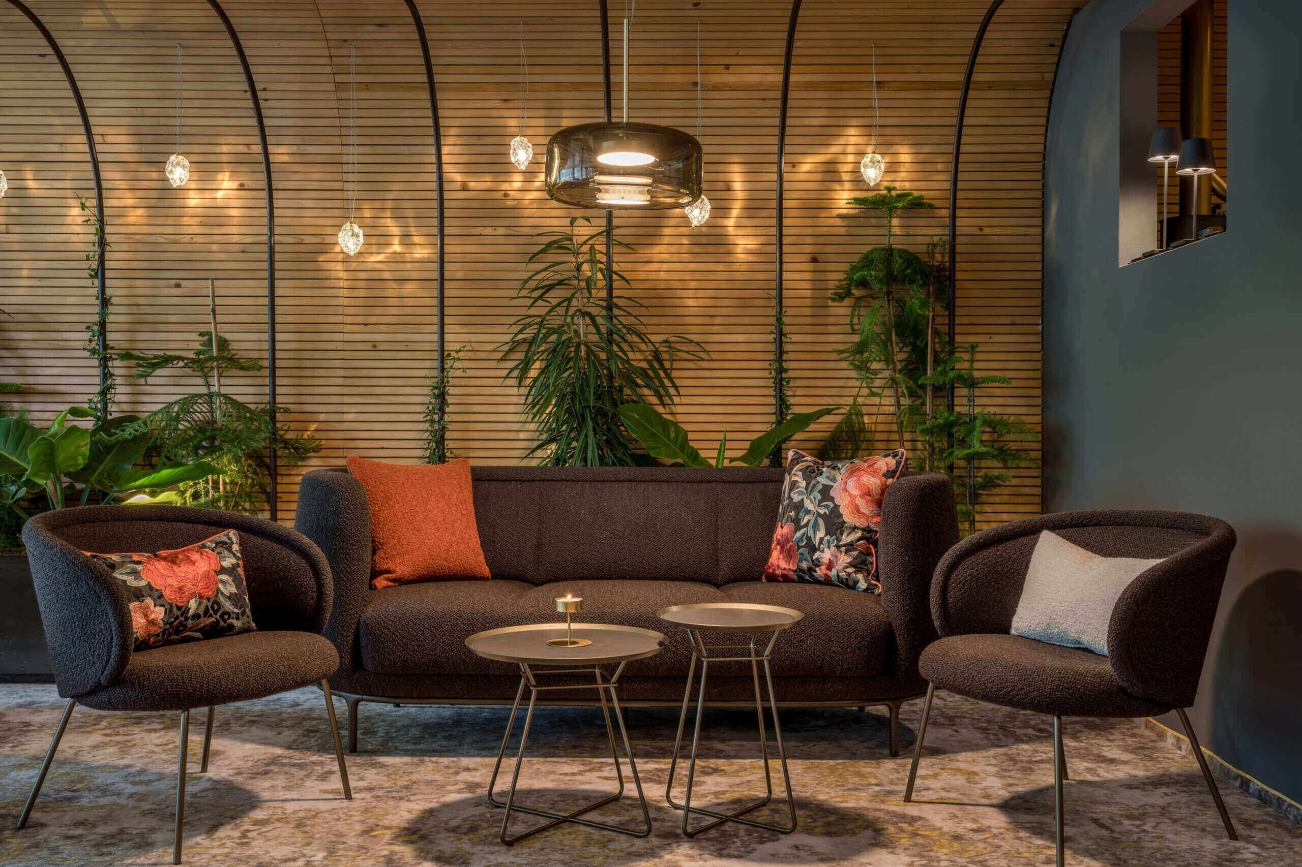 Modernes Lounge-Setup mit Sofa, Stühlen und Pflanzen im Designhotel Bad Hofgastein