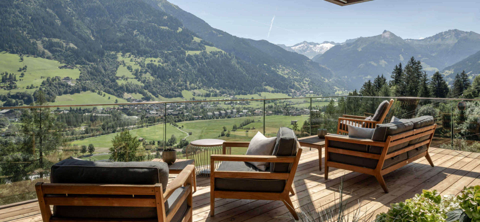 Terrasse mit Holzstühlen und Bergpanorama im Designhotel DAS.GOLDBERG im Salzburger Land