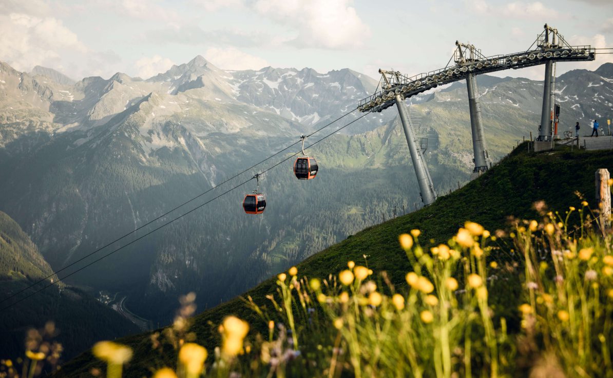 Gondelbahn und blühende Alpenwiese mit Bergpanorama im Gasteinertal für Wanderhotelurlaub