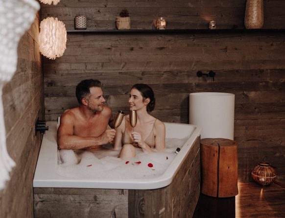 Paar in Badewanne mit Sektgläsern