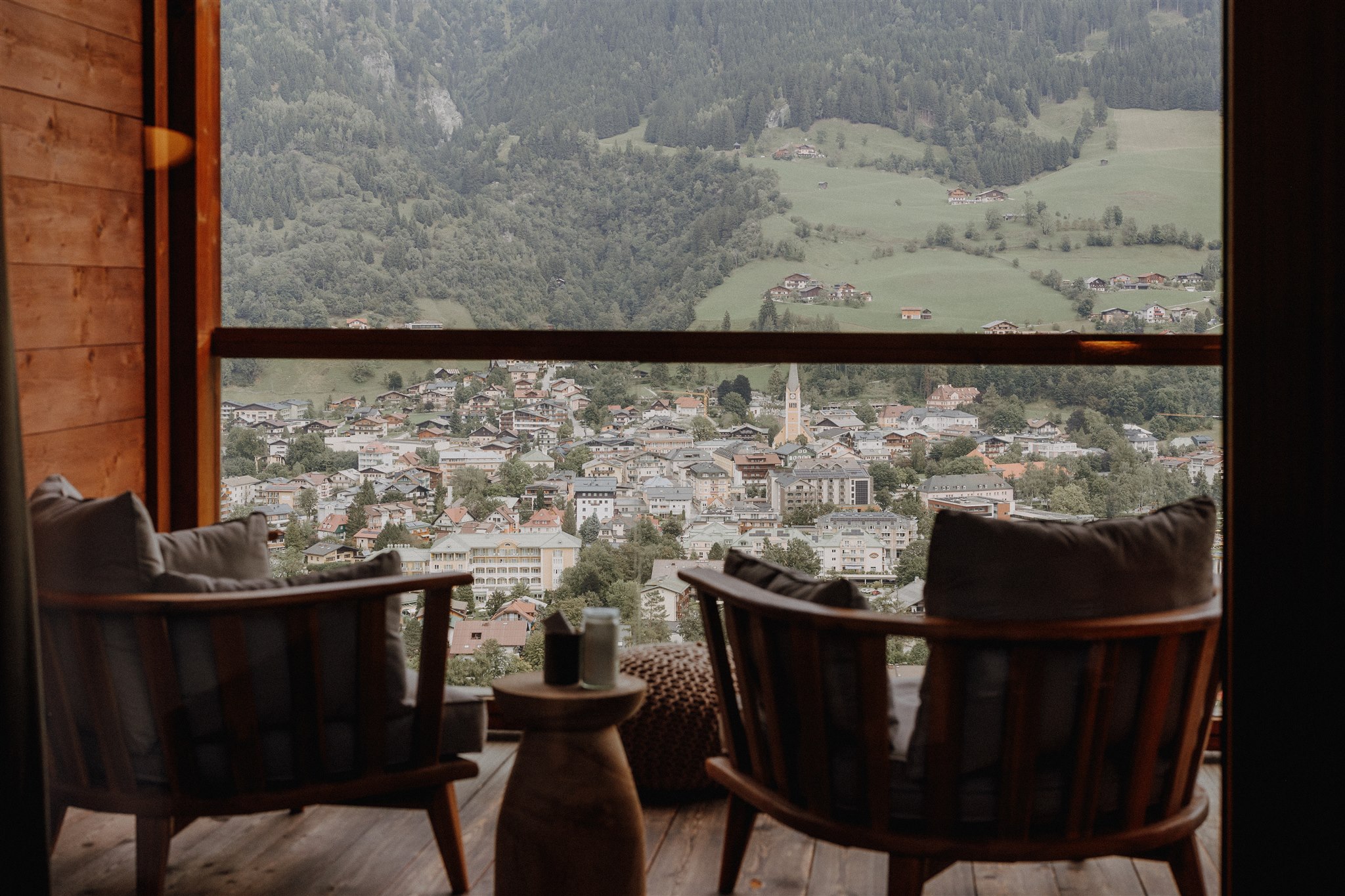 Zwei Sessel mit Blick auf Tal und Berge durch großes Fenster