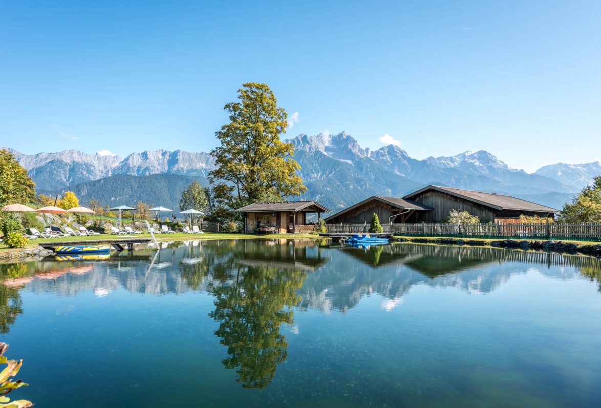 Idyllischer Badeteich am Hinterburghof mit traumhafter Bergkulisse in Saalfelden, Salzburg.