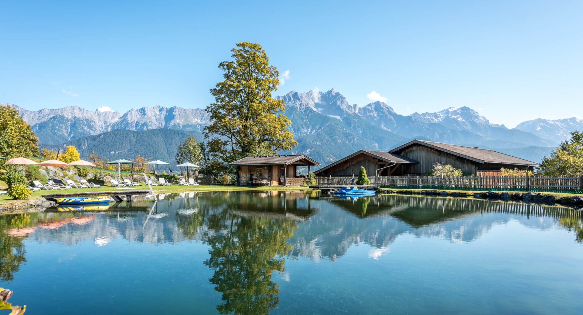 Idyllischer Badeteich am Hinterburghof mit traumhafter Bergkulisse in Saalfelden, Salzburg.