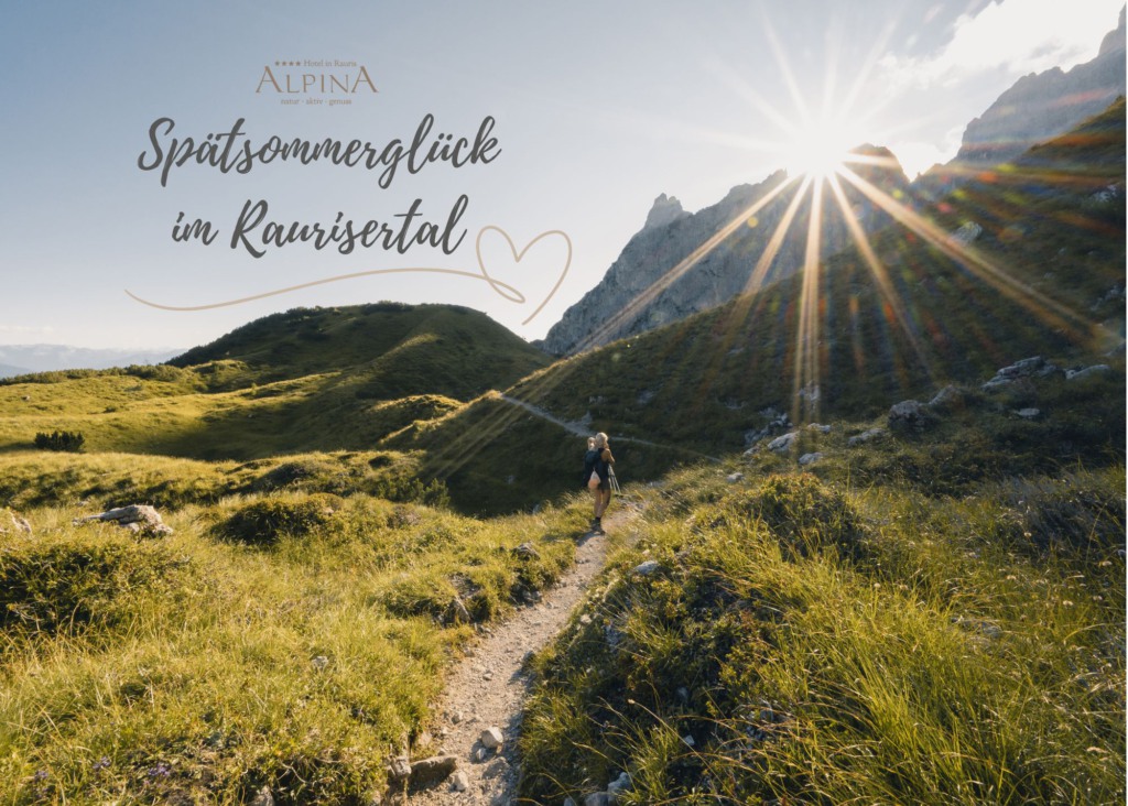 Turistka na horské stezce mezi zelenými alpskými loukami a skalami ve slunečním světle