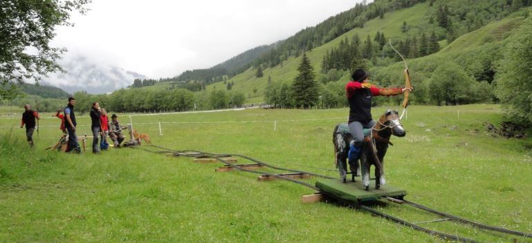 Bogenschütze auf einem Pferd trainiert im Jagdbogenclub Rauris in der Natur.