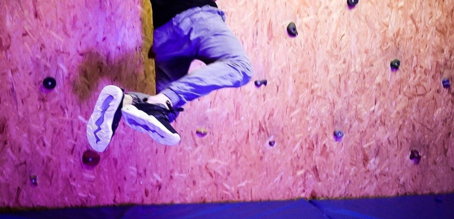 Jugendlicher springt an Indoor-Kletterwand im Jugendhotel Tauernhof, Action und Spaß in Obertauern