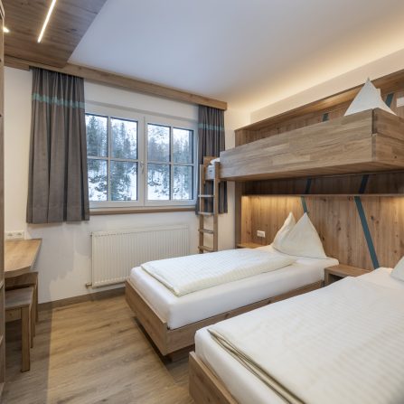 Jugendlicher klettert konzentriert an Boulderwand im Indoor-Bereich des Jugendhotels Tauernhof