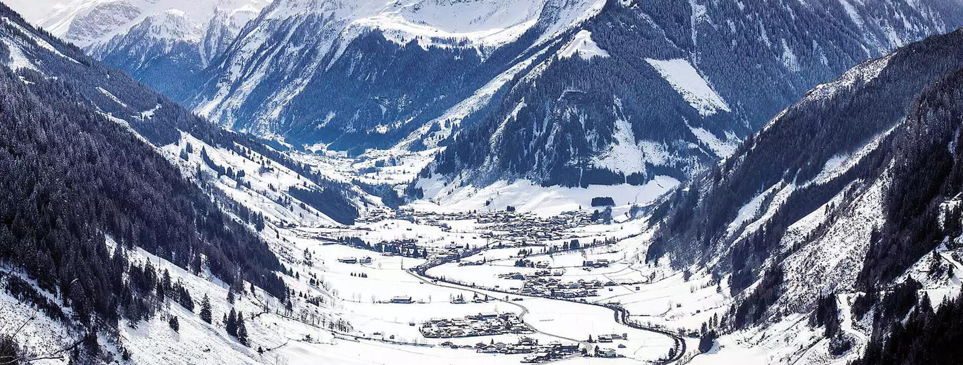 Winterliche Berglandschaft mit Rauris im Tal, umgeben von schneebedeckten Höhenlagen.