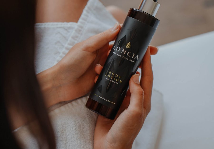 Frau hält LONCIA Body Lotion mit Hopfenextrakt für sanfte, nachhaltige Hautpflege