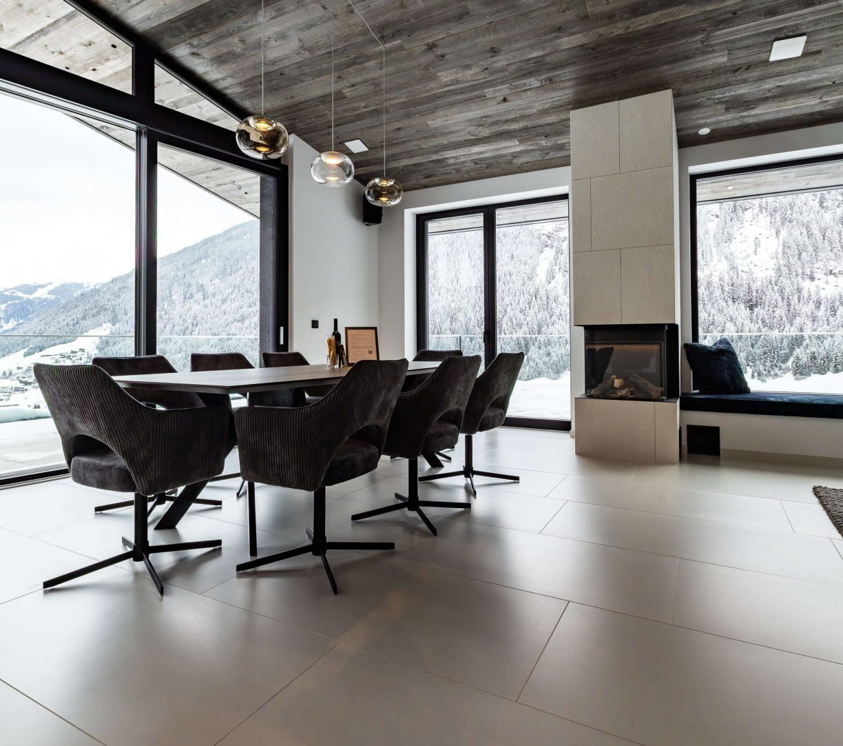 Elegantes Esszimmer mit Bergblick und modernem Kamin im Mountain Chalet Kappl, Tirol.