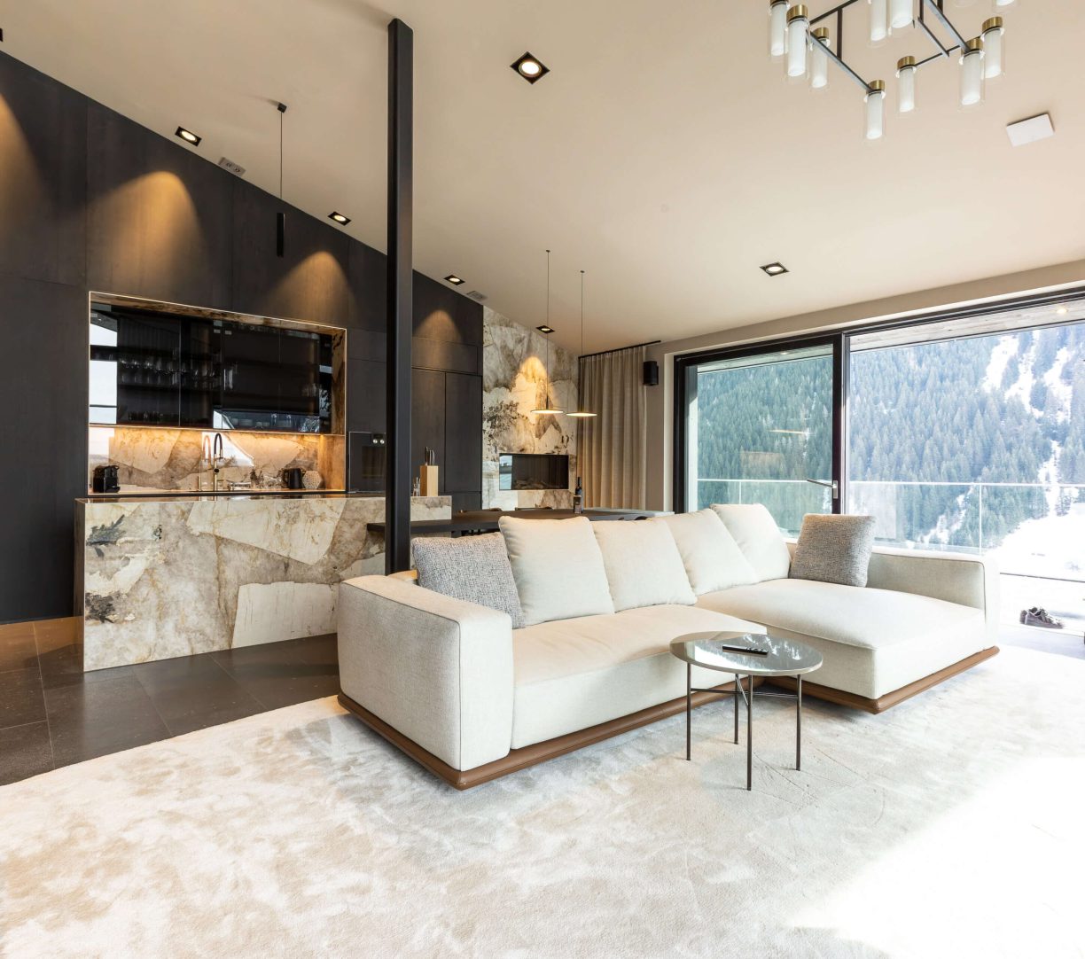 Modernes Wohnzimmer im Luxus-Chalet mit Aussicht auf die Tiroler Alpen und eleganter Einrichtung.