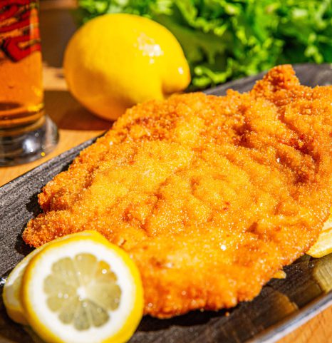 Knuspriges Wiener Schnitzel mit Pommes und Zitrone im familienhotel Salzkammergut am Attersee