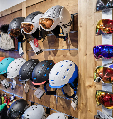 Vielfältige Skihelme und -brillen im Skishop Bad Hofgastein, bereit für den Skiverleih.