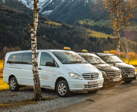 Moderne Mercedes-Taxis stehen in malerischer Berglandschaft bereit für Fahrten in Saalbach.