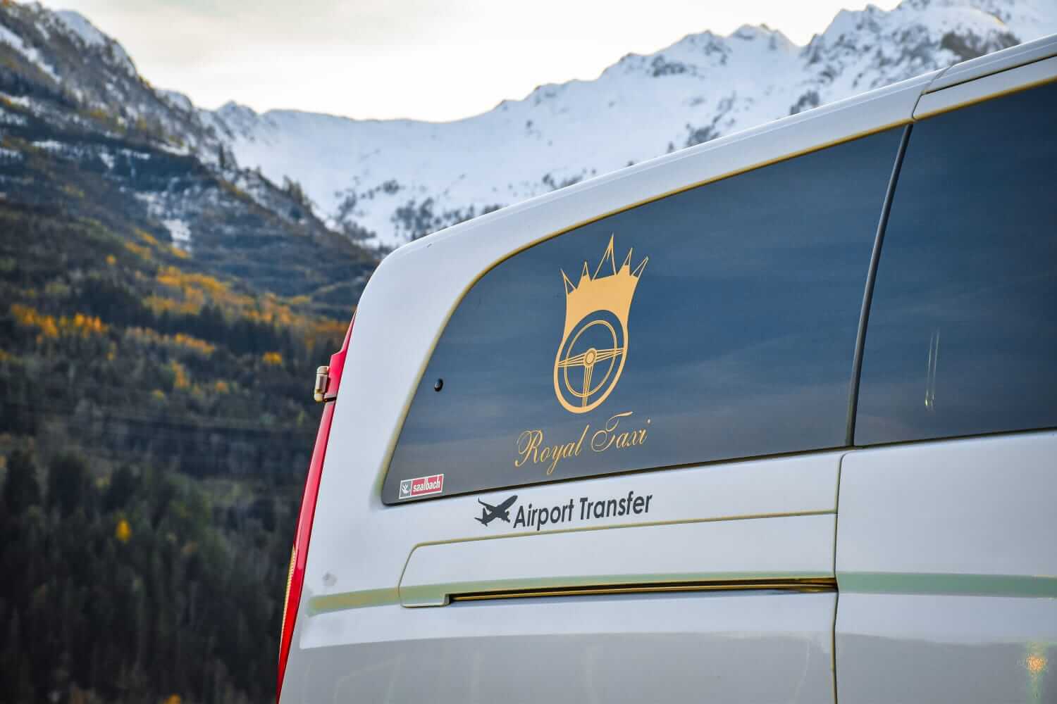 Logo und Aufschrift „Royal Taxi“ auf einem Fahrzeug im Gebirge für Airport-Transfers.