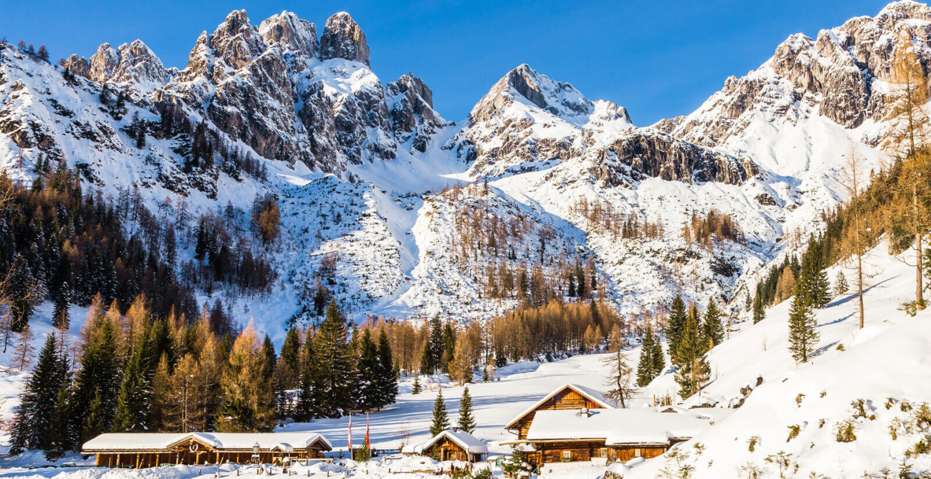 Berglandschaft mit schneebedeckten Gipfeln und der Unterhofalm in alpiner Atmosphäre.