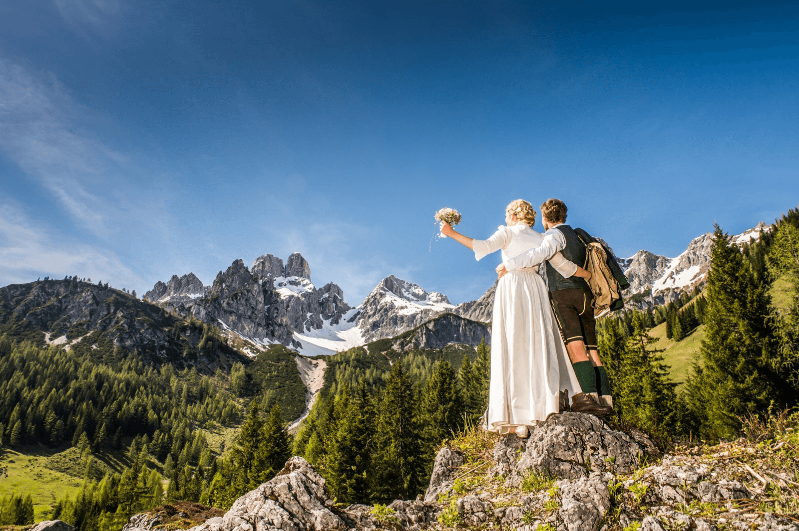 Brautpaar in alpine Kulisse, umgeben von Bergen, ideal für Hochzeiten auf der Unterhofalm.