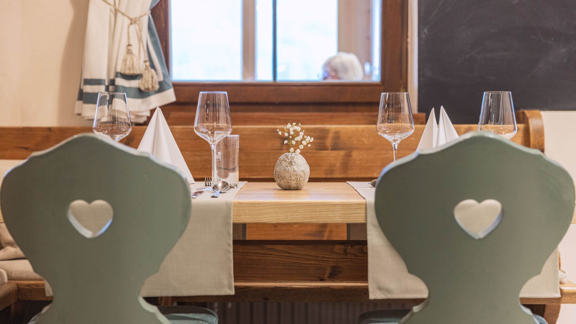 Gemütlich gedeckter Holztisch im Hotel Weissenstein mit stilvollen Gläsern und Deko