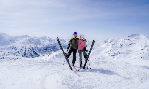 Paar mit Skiern auf verschneitem Bergpanorama